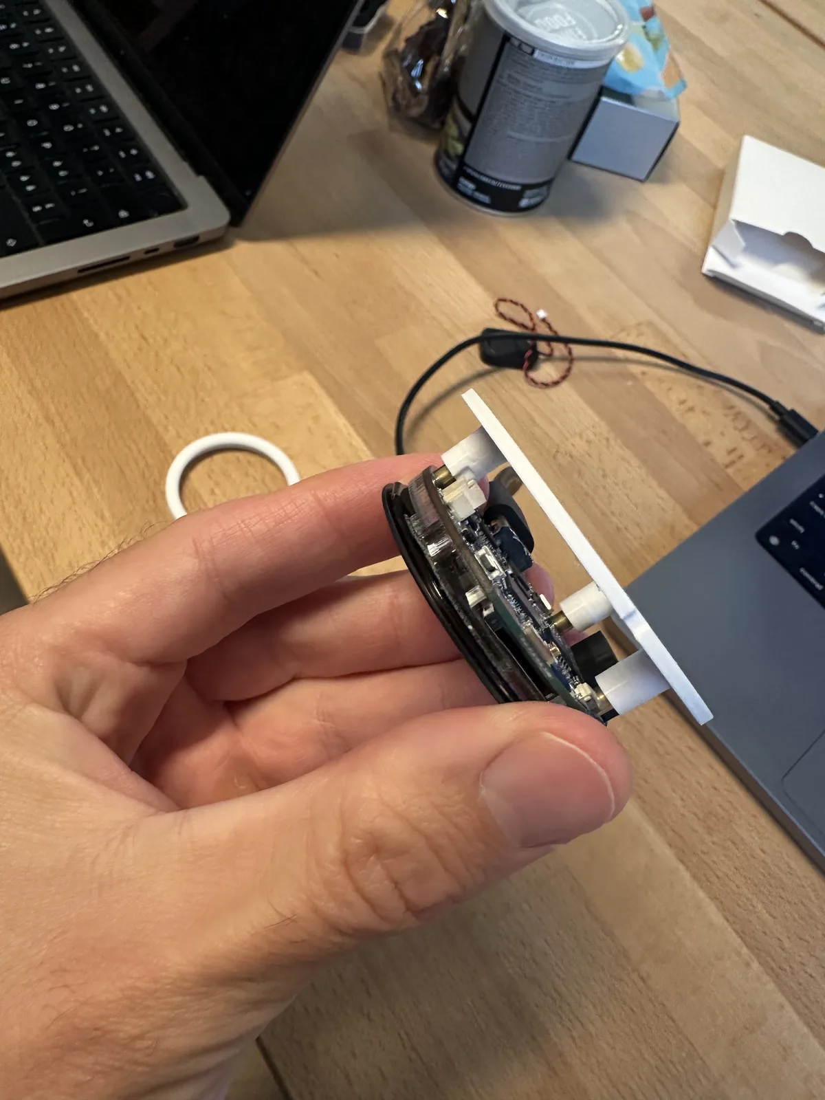 Side view of the display and circuit board held against a white printed mount