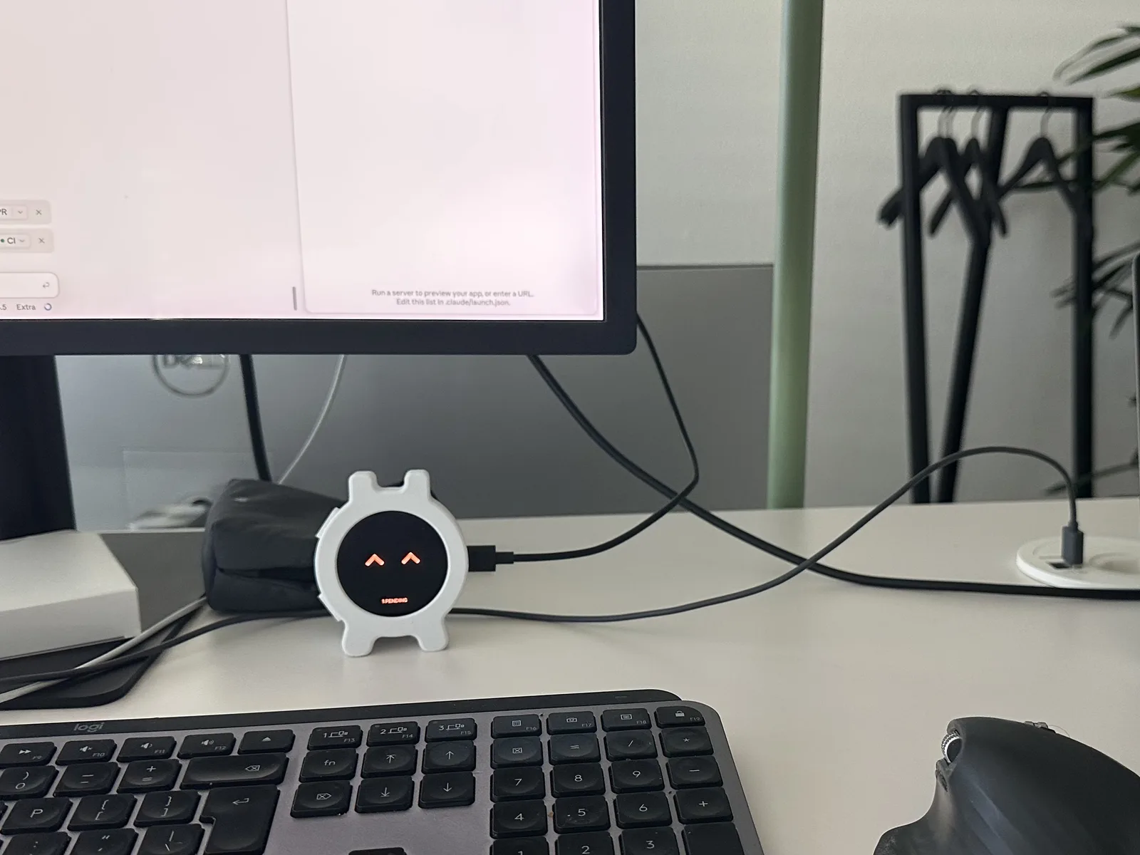Desk companion connected by USB below a monitor, beside a keyboard